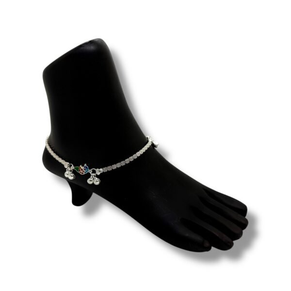 A silver chain featuring a delicate charm alongside a beautifully crafted bird anklet set.